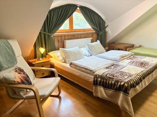 a bedroom with a bed and a chair and a window at Dębowa Dziupla in Białowieża