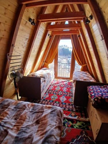 a room with two beds and a window in a cabin at Vila Prevoja in Nova Varoš