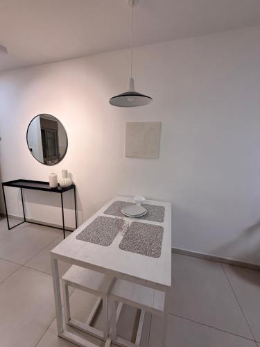 a white room with a table and a mirror at Sunset suite - step from the beach in Ashkelon