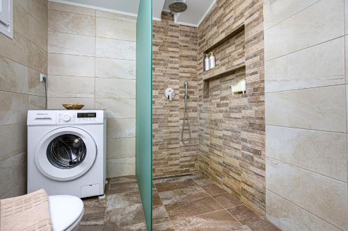 a bathroom with a washing machine and a shower at Villa Pines in Limenaria