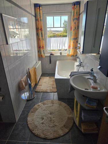 a bathroom with a bath tub and a sink at Ferienhaus mit Naturblick in Putbus