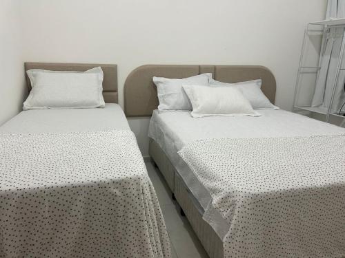 two beds sitting next to each other in a room at Casa com Piscina - Condomínio - Próx a Praia in Marechal Deodoro