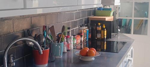 a kitchen counter with a sink and a bowl of oranges at La Pause Bleue in Dinard