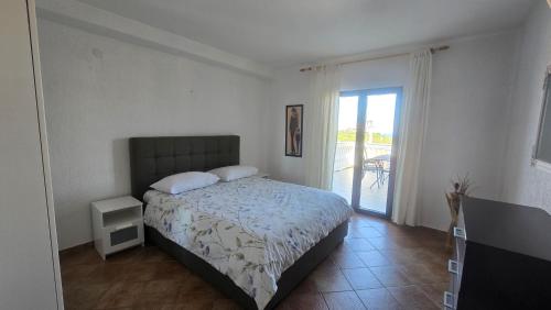 a bedroom with a bed and a door to a patio at Apartments and room Suza in Senj
