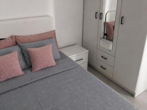 a bedroom with a bed with pink pillows and a mirror at Smolović Luxury Apartments Herceg Novi-Sea View,Free Parking in Zelenika