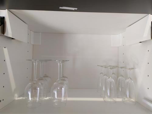 a bunch of wine glasses are lined up on a wall at Calme et Volupté in Maxilly-sur-Saône