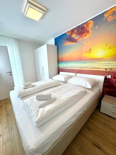 a bedroom with two beds with a painting on the wall at Beach SUN and FUN in Podersdorf am See