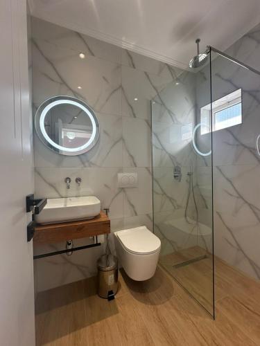 a bathroom with a toilet and a sink and a shower at Seli's White Villa in Ksamil