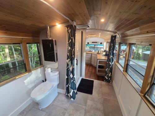 a bathroom in an rv with a toilet and a sink at Lazy T Cabins - The Skoolie in Robbinsville