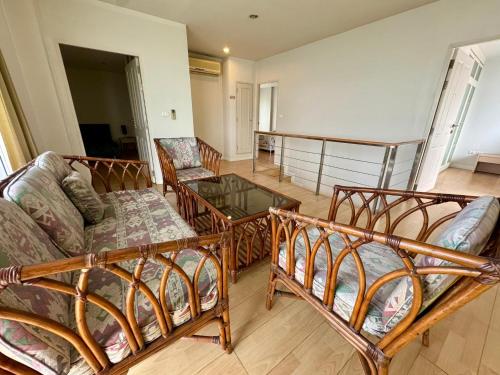 a living room with three beds and a glass table at Duplex 21 Apartment in Bangkok