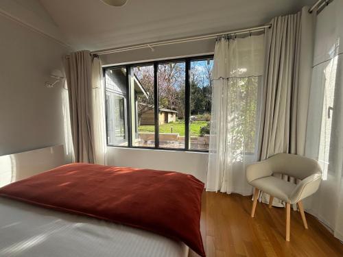 a bedroom with a bed and a chair and a window at La Maison d'Amboise in Amboise