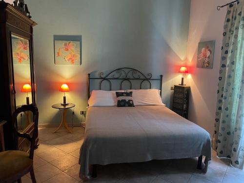 a bedroom with a bed with two lamps and two tables at Agriturismo S.Lucia in Roccaforte Mondovì