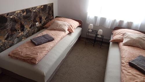 two beds sitting next to each other in a bedroom at BORINA VENDÉGHÁZ in Sátoraljaújhely