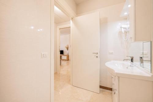 a white bathroom with a sink and a shower at Vacanze Residence Mimose - con parcheggio relax tra pineta e spiaggia in Eraclea Mare