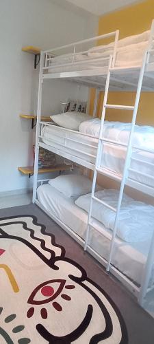 a room with bunk beds with a rug on the floor at La Pause Bleue in Dinard