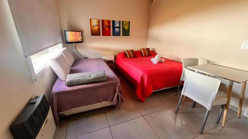 a small room with a bed and a table at Casa Choique in Villa El Chocón