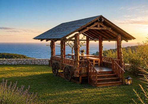 a wooden gazebo with a table in it at Panoramic Sea View Wooden Cottage Ratzakli, Kefalonia in Ratzaklíon