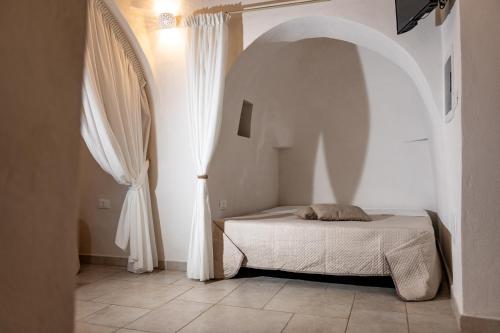 a bedroom with a bed and an arched window at Trullo MaPì in San Michele Salentino