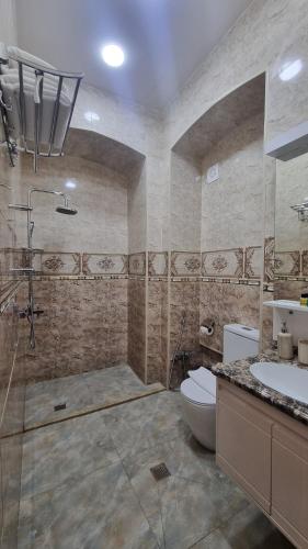 a bathroom with a shower and a toilet and a sink at Grand Hotel 1902 in Baku