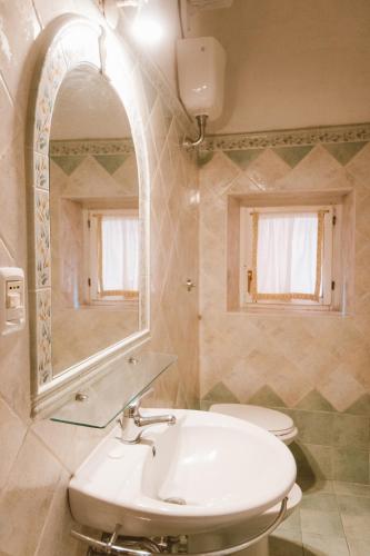 a bathroom with a sink and a toilet and a mirror at Loft Raffaello 22 in Urbino