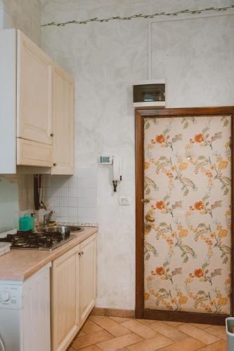 a kitchen with a door with a floral wallpaper at Loft Raffaello 22 in Urbino