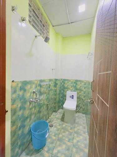 a bathroom with a toilet and a blue bucket at RASHI Lodge Attibale in Attibele