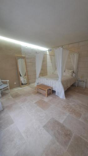 a room with a bed with curtains on it at Le logis troglodyte in Loches