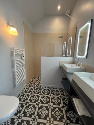 a bathroom with two sinks and a toilet at La Maison d'Amboise in Amboise