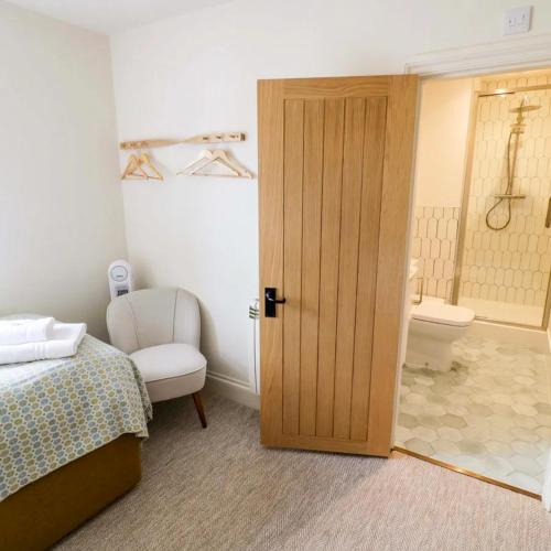 a bedroom with a door to a bathroom with a toilet at Bay House in Broadway