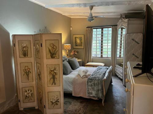 a bedroom with a bed and a large window at Greyton Cottage in Greyton
