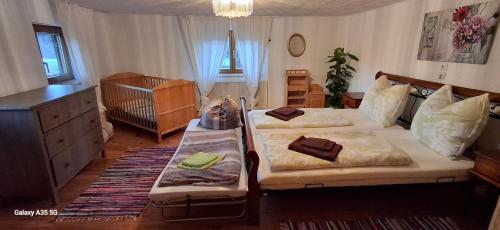 a bedroom with two beds and a crib at Romantikhäuschen zum Dachsteinblick in Abtenau