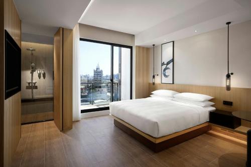 a bedroom with a large bed and a large window at Fairfield by Marriott Taichung in Taichung