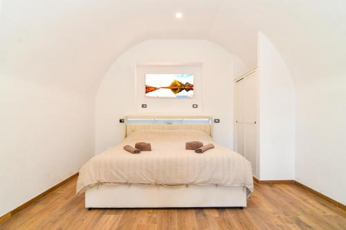 a bedroom with a bed in a white room at CáMillina in Santa Maria Maggiore