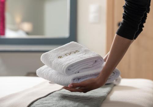 a person holding a stack of towels at Enos Retreat Villas in Agios Nikolaos