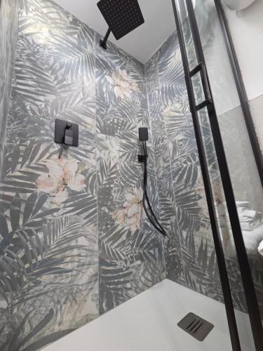 a shower with a floral patterned wall at B&B Del Paradiso in Bergamo