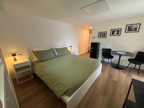 a bedroom with a large green bed and two chairs at B&B Del Paradiso in Bergamo