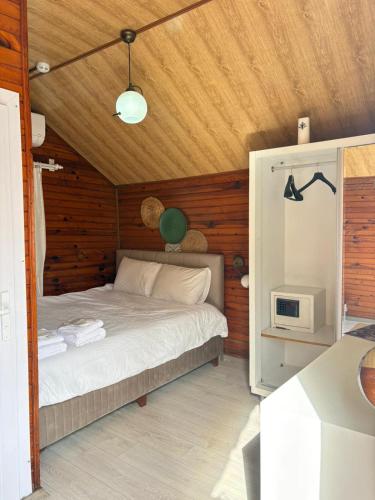 a bedroom with a bed with a wooden ceiling at Kuba pansiyon in Side