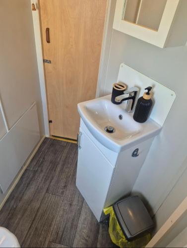 a small bathroom with a sink in a room at Jams Caravan in Skegness