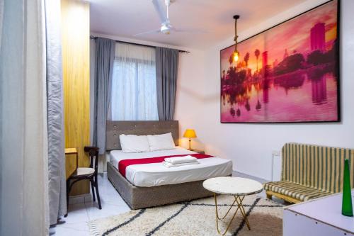 a small bedroom with a bed and a chair at Artist sanctuary lakeview phase4 in Mto Panga