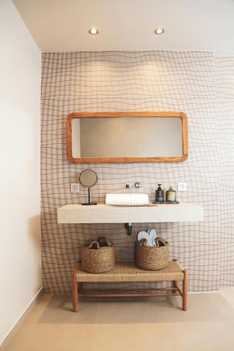un bagno con un lavandino e una panca con uno specchio di Hôtel Casa C a Propriano