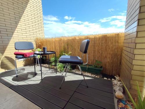 a patio with two chairs and a table and a fence at Guest House Douro in Vila Nova de Gaia