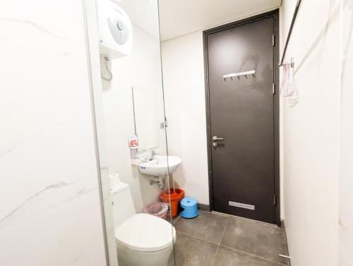 a bathroom with a toilet and a black door at Lovina 20-AE at One Residence in Batam Center