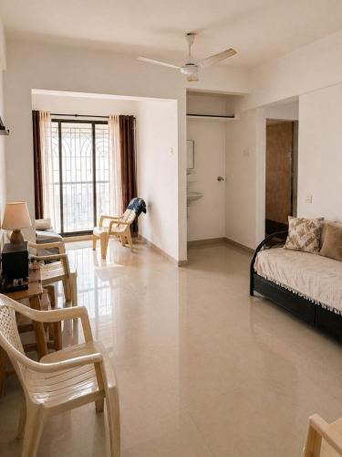 a living room with a bed and a table and chairs at Sk Holiday Apartment in Alibaug