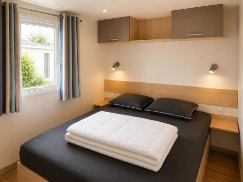 a bedroom with a large bed with a window at Camping de la Baie-Baie de Somme-Sites et Paysages in Pendé