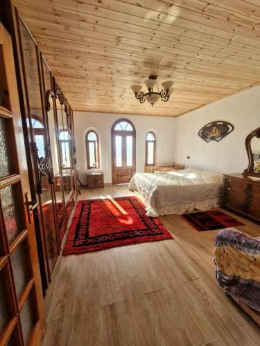 a large bedroom with a bed and a wooden ceiling at Hidden Gem Villa in Guri i Zi