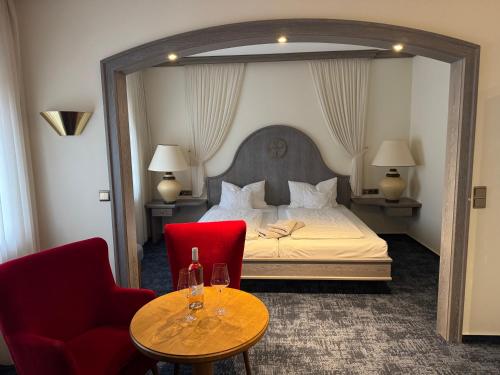 ein Hotelzimmer mit einem Bett, zwei Stühlen und einem Tisch in der Unterkunft Hotel Feldmann in Münster