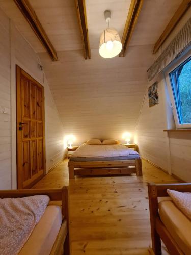 a bedroom with two beds in a room with a window at Dom wakacyjny nad jeziorem, Mazury in Samin