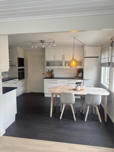 a kitchen with a table and chairs in a room at Central Home in Mandal in Mandal