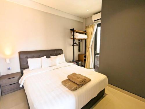 a bedroom with a large white bed with two towels on it at Lovina 3-AH at One Residence in Batam Center