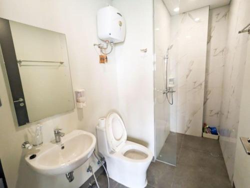 a white bathroom with a toilet and a sink at Lovina 3-AH at One Residence in Batam Center